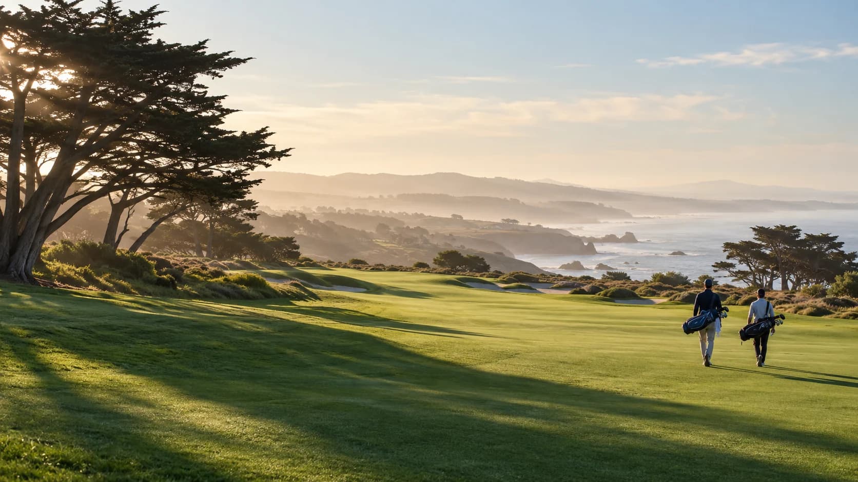 Two golfers walking across a sunlit coastal fairway beneath cypress trees